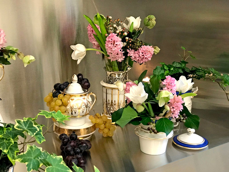 teapot is adorned with bunches of different colours of grapes