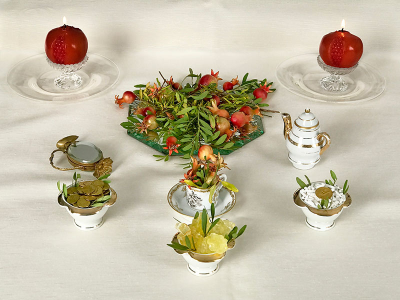 miniature sofreh with pomegranates, coins, candles