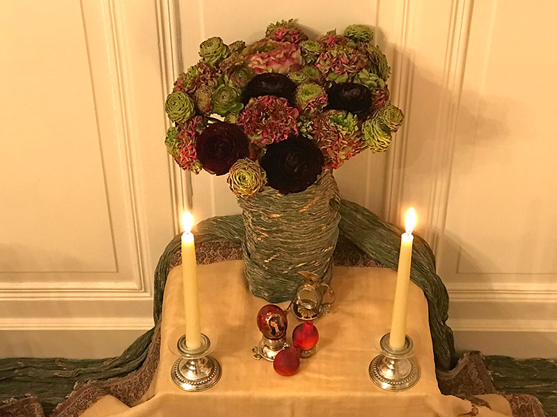 bouquet of ranunculi, sculptured pomegranate, candles