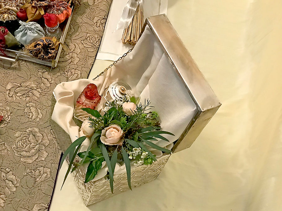 silver box with roses, foliage, bottle of rosewater