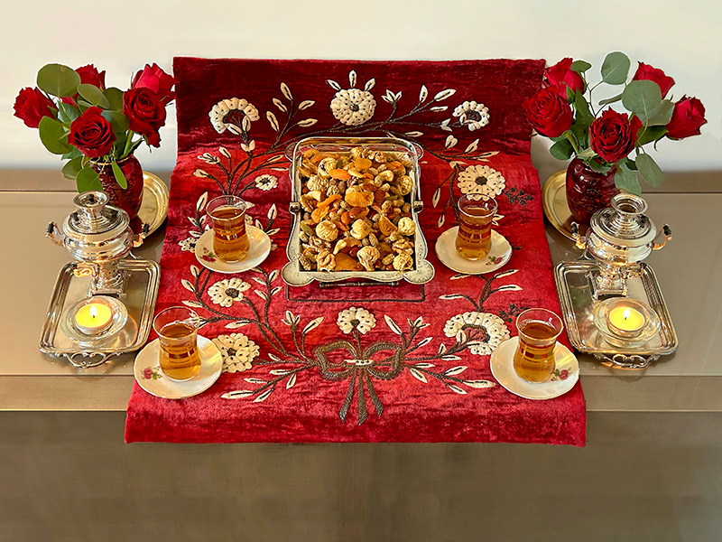Tea and a pair of miniature samovars, tea lights, roses, dried fruits and nuts