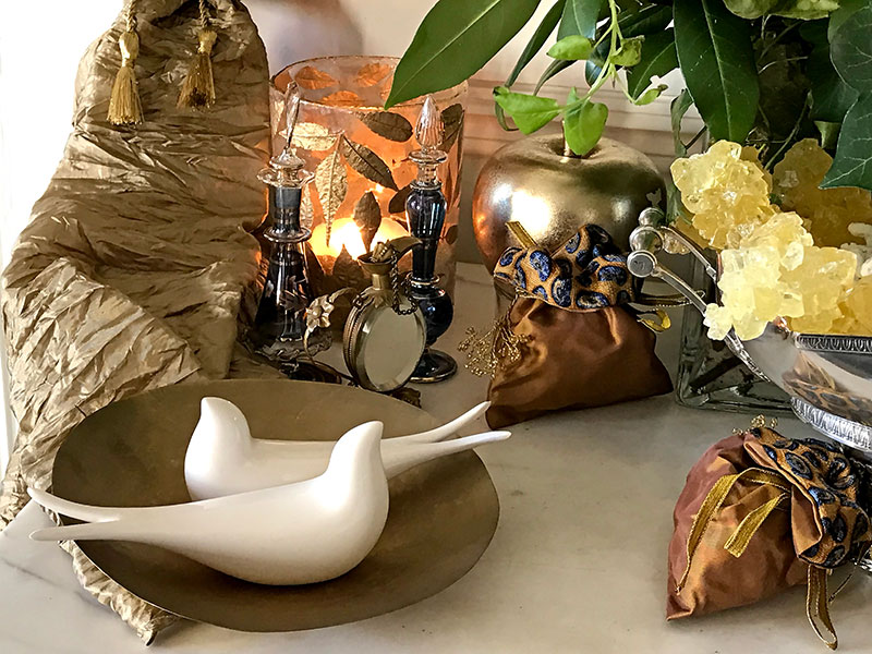 ceramic birds, flasks, gold bonbonnieres, and tea lights