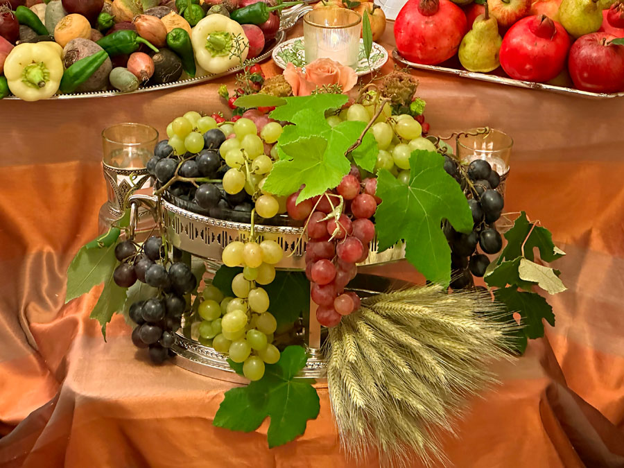 grapes hang from the tiered antique crystal and silver-plated container