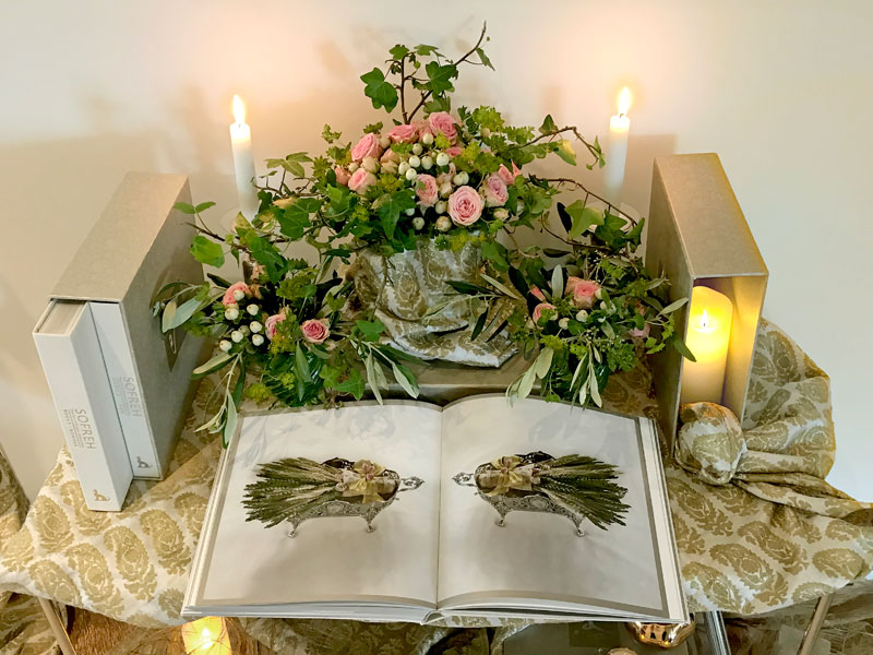ggg12MayIMG_9645 several volumes of the book with softly illuminated delicate bouquets of pink spray roses, hypericum and foliage, and lengths of elegantly draped fine textiles